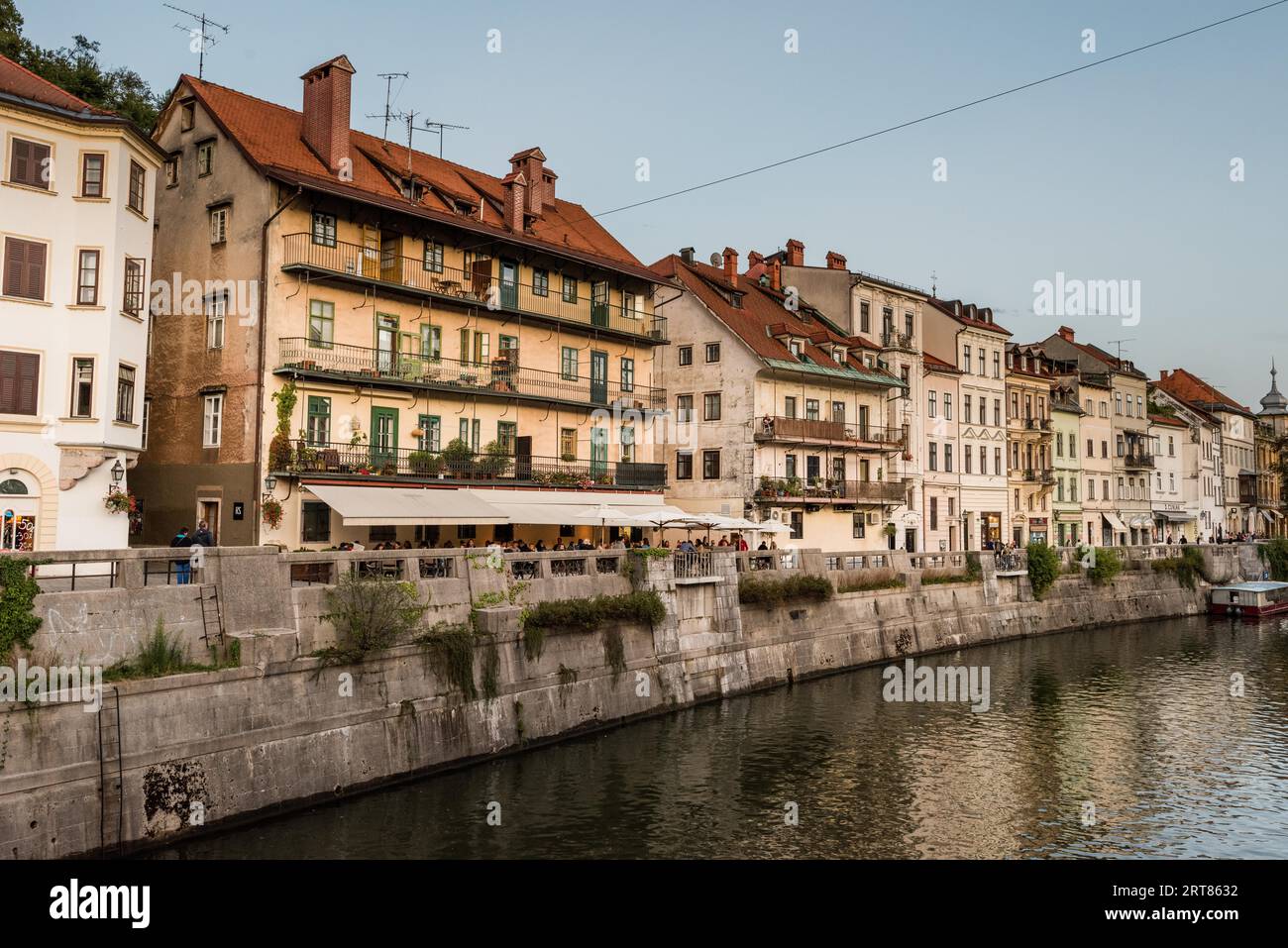 The canalized banks of on the Ljubljanica river in the slovenian capital city Ljubljana with the old houses and restaurants on sunny day in summer Stock Photo