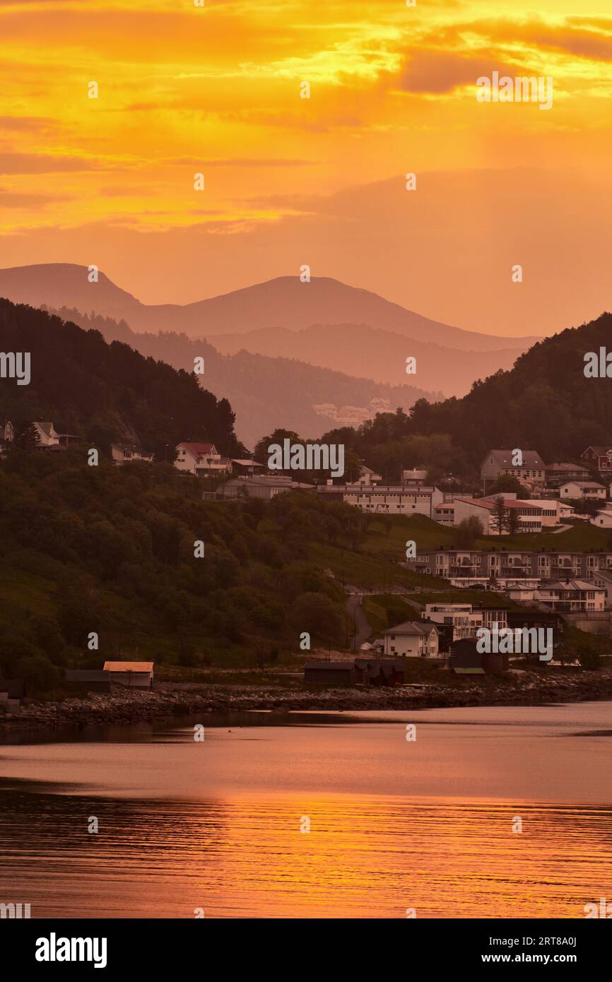 Golden sunrise with little houses on hills in norway Stock Photo