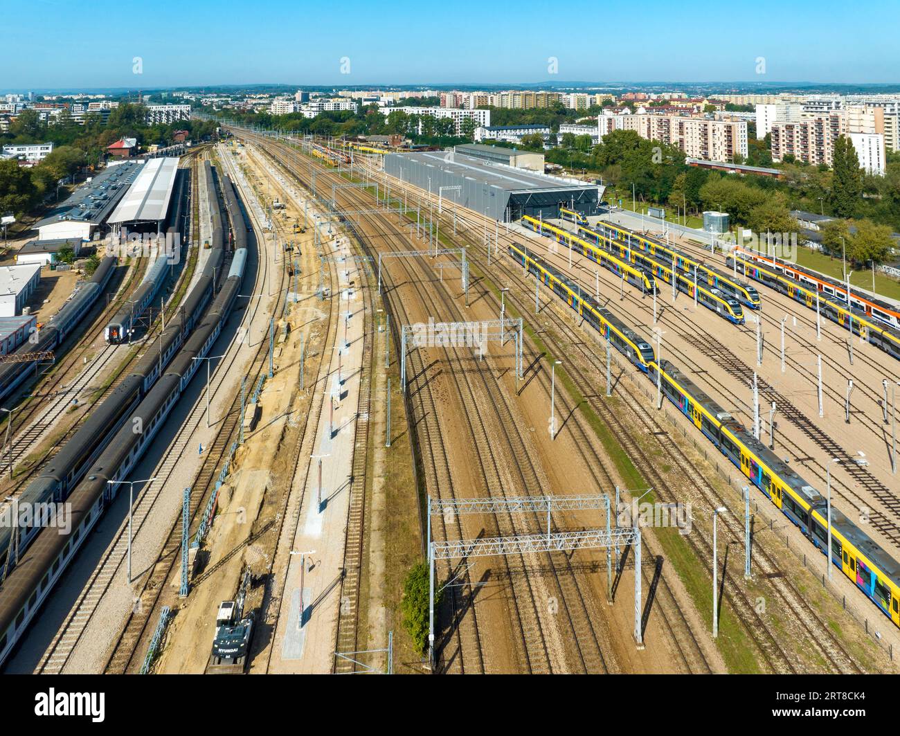 Krakow, Poland. Big train hub, outdoor and indoor garage with train sheds, fast city trains, old and new carriages, many railroad tracks, rails and el Stock Photo