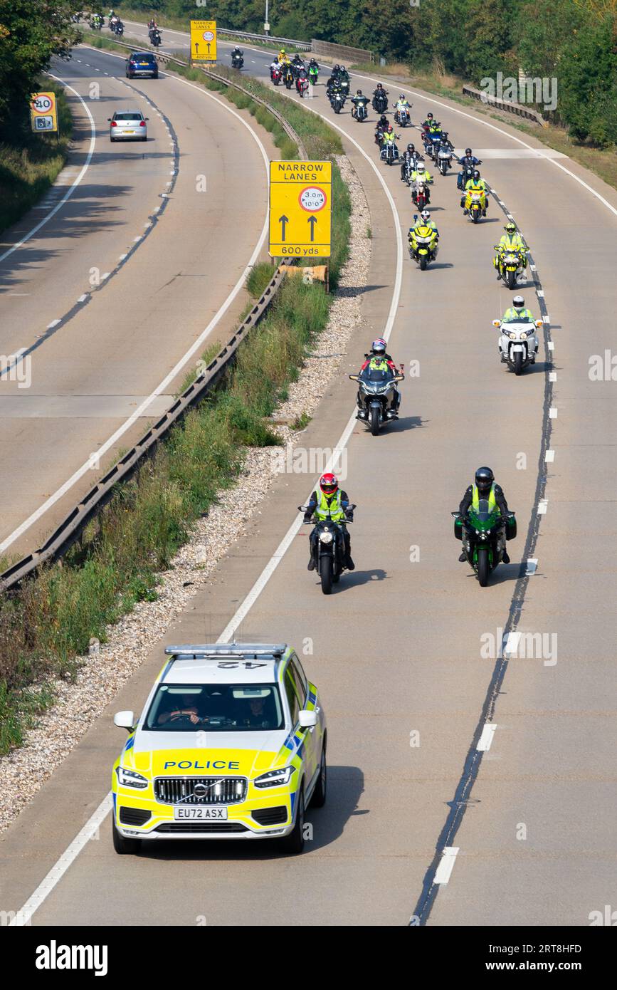Motorcycle convoy with police escort on the A12 at Galleywood near Chelmsford, Essex, UK. Charity motorbike run for Essex & Herts Air Ambulance Trust Stock Photo