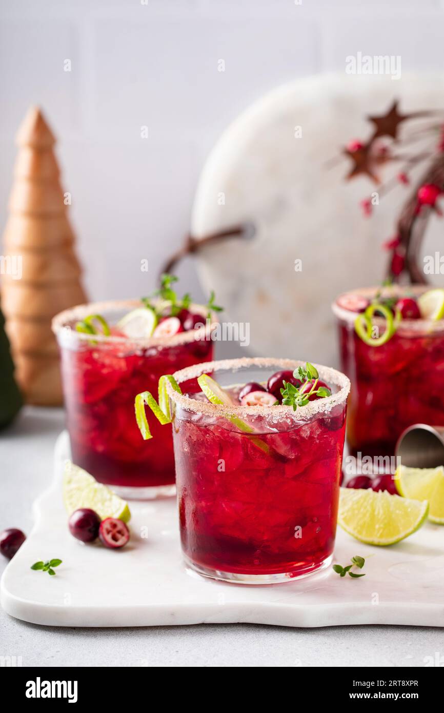 Christmas cranberry and lime margarita cocktail garnished with lime zest swirl Stock Photo