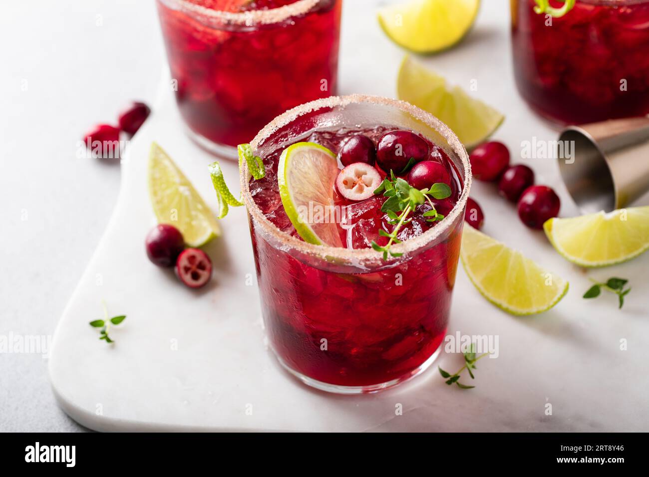 Christmas cranberry and lime margarita cocktail garnished with lime zest swirl Stock Photo