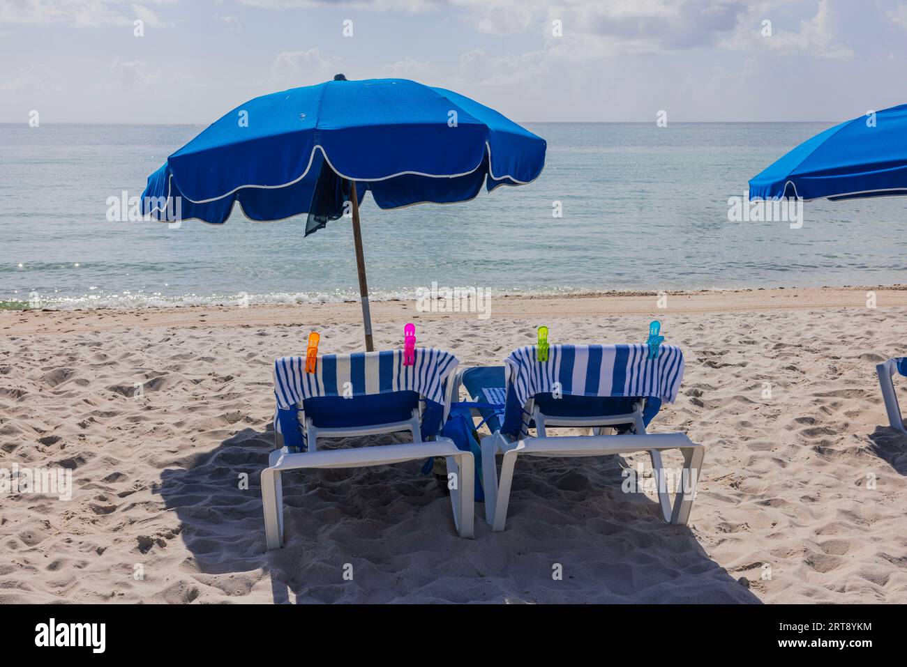 Beautiful view of sandy beach of Atlantic Ocean with sun loungers covered with towels and umbrellas. Miami Beach. USA. Stock Photo