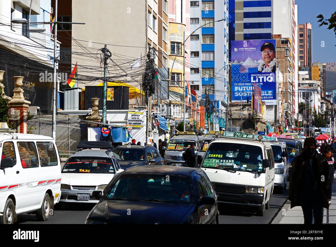 La Paz, BOLIVIA; September 11th 2023: Traffic jams on Av 6 de Agosto in central La Paz, with Bolivian president Luis Arce Catacora on a hoarding promoting the 'Industrialisation of lithium, a big step towards a sustainable future for Bolivia' in the background. Bolivia has some of the world's largest lithium reserves in the Salar de Uyuni salt flat, the development of which is central to the govenrnment's economic policy. This year Bolivia has signed agreements with the Chinese battery maker CATL and the Citic Guoan Group, and Russian state firm Rosatom to develop these resources. Stock Photo
