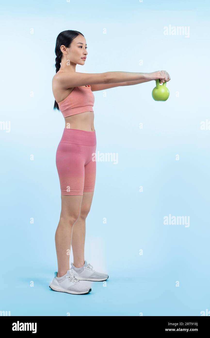 Vigorous energetic woman doing kettlebell weight lifting exercise on
