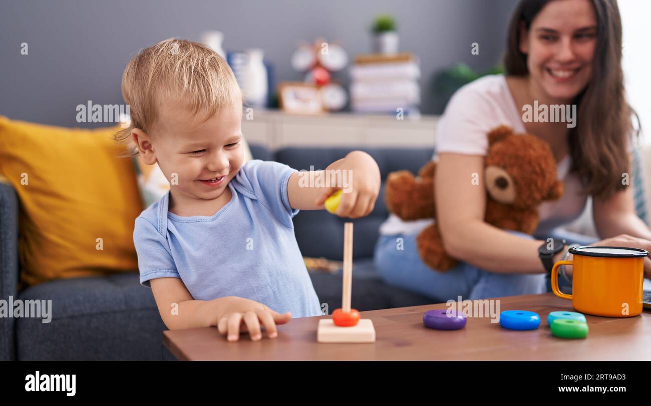 Mother and son holding teddy bear playing at home Stock Photo - Alamy