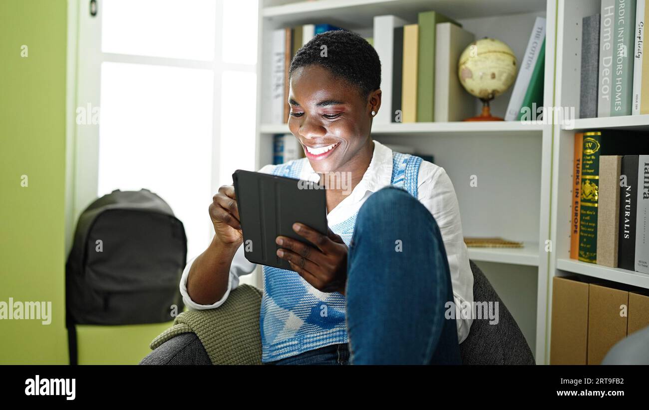 African american woman student using touchpad studying at library ...