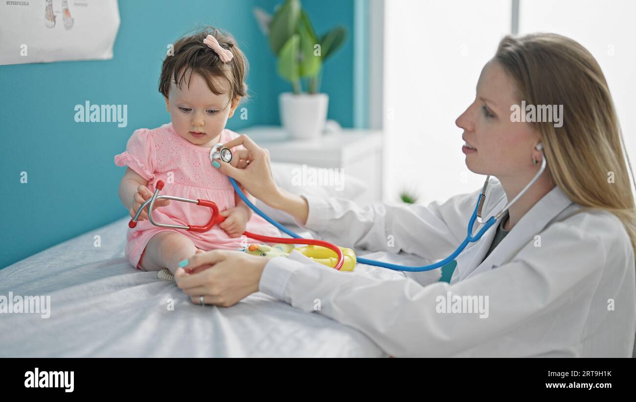 Mother and daughter pediatrician examining baby chest at clinic Stock Photo