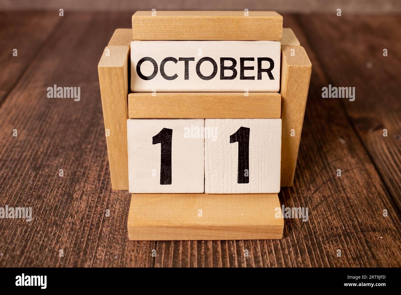 White block calendar present date 11 and month October on wood background. Stock Photo