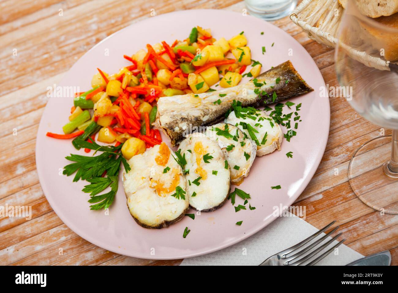 Oven baked hake with vegetable garnish Stock Photo