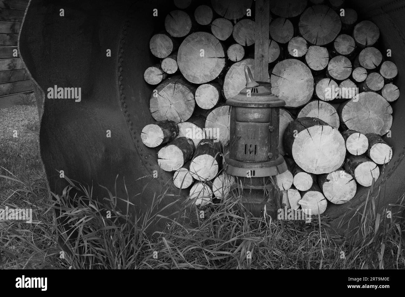 Wood piled up in an old metal pipe with pot belly wood stove in Creede Colorado Stock Photo