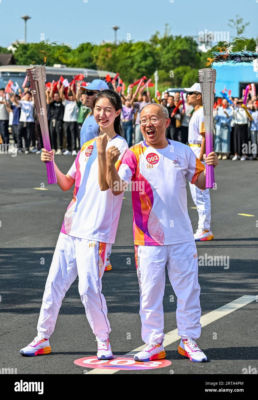 Ningbo, China's Zhejiang Province. 12th Sep, 2023. Torch bearers Cui Yiwen (L) and Qian Haijun pose during the torch relay of the 19th Asian Games in Ningbo, east China's Zhejiang Province, Sept. 12, 2023. Credit: Sun Fei/Xinhua/Alamy Live News Stock Photo