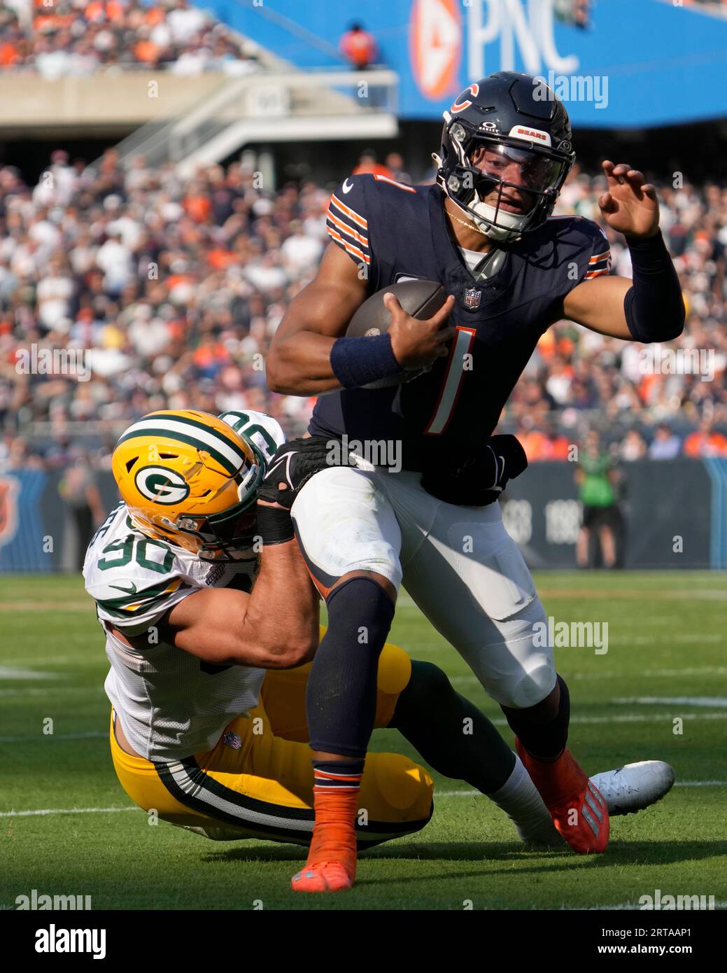 Chicago Bears quarterback Justin Fields carries the ball as Green Bay  Packers linebacker Lukas Van Ness makes the tackle during an NFL football  game against the Green Bay Packers Sunday, Sept. 10