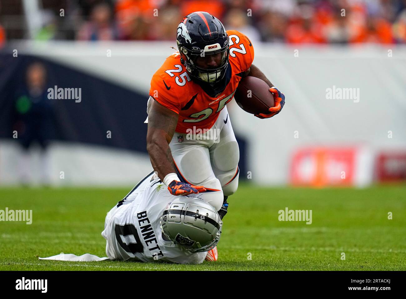 Samaje Perine of the Denver Broncos runs past Nate Hobbs of the Las News  Photo - Getty Images