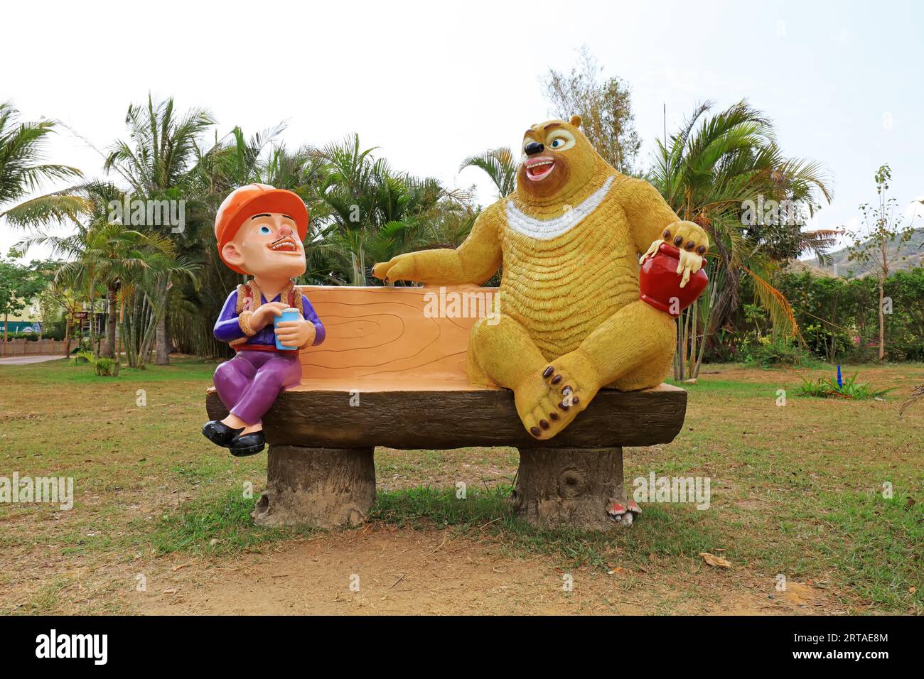 Giant bear and bareheaded cartoon sculpture in park, Sanya, South China Stock Photo