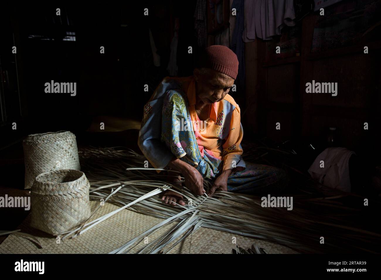 Koh Yao, Thailand; 1st January 2023 Senior woman making a basket with dried palm leaves Stock