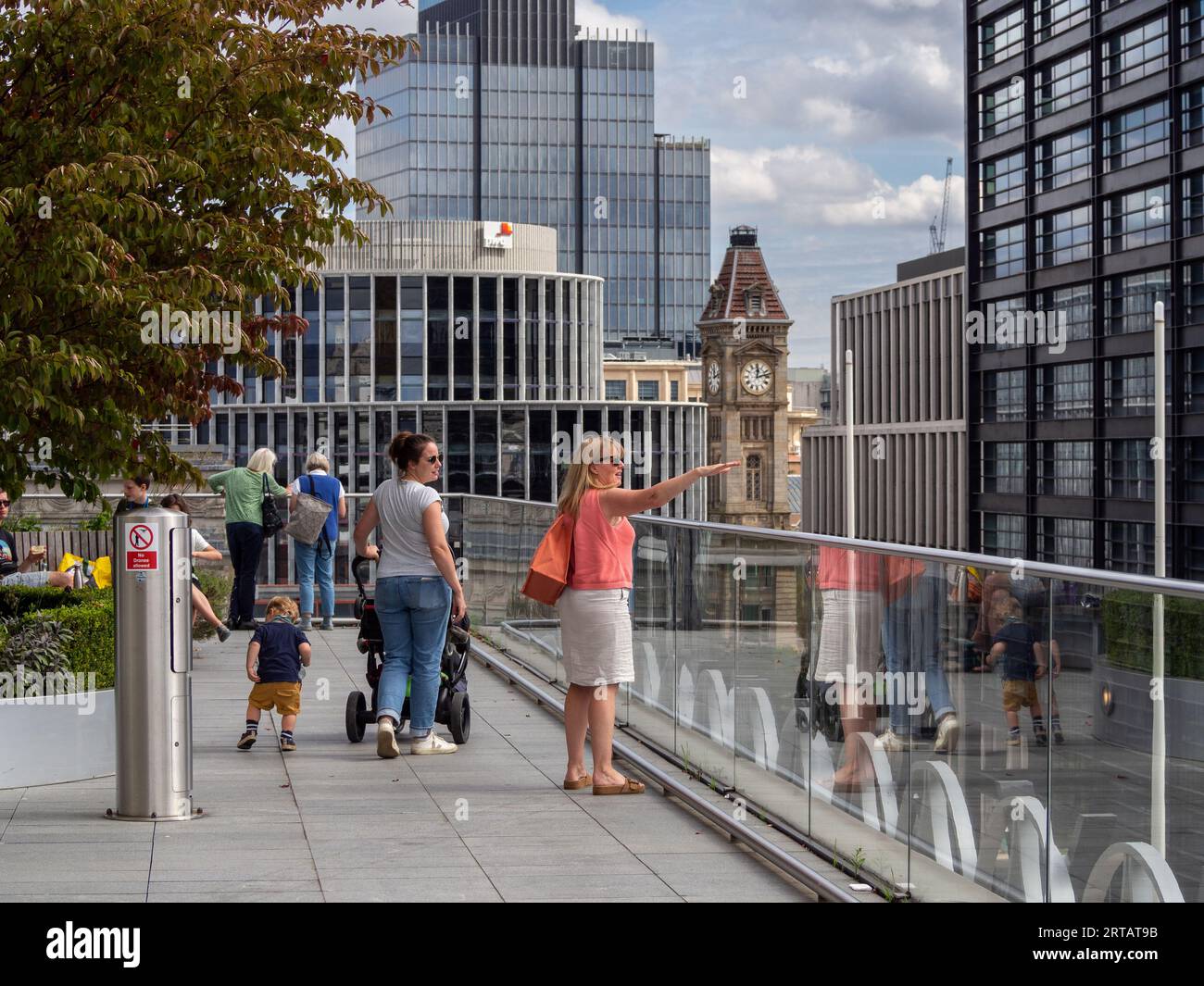 Visitors to the terrace at the Library of Birmingham taking in views of the City Centre skyline; Birmingham, UK Stock Photo