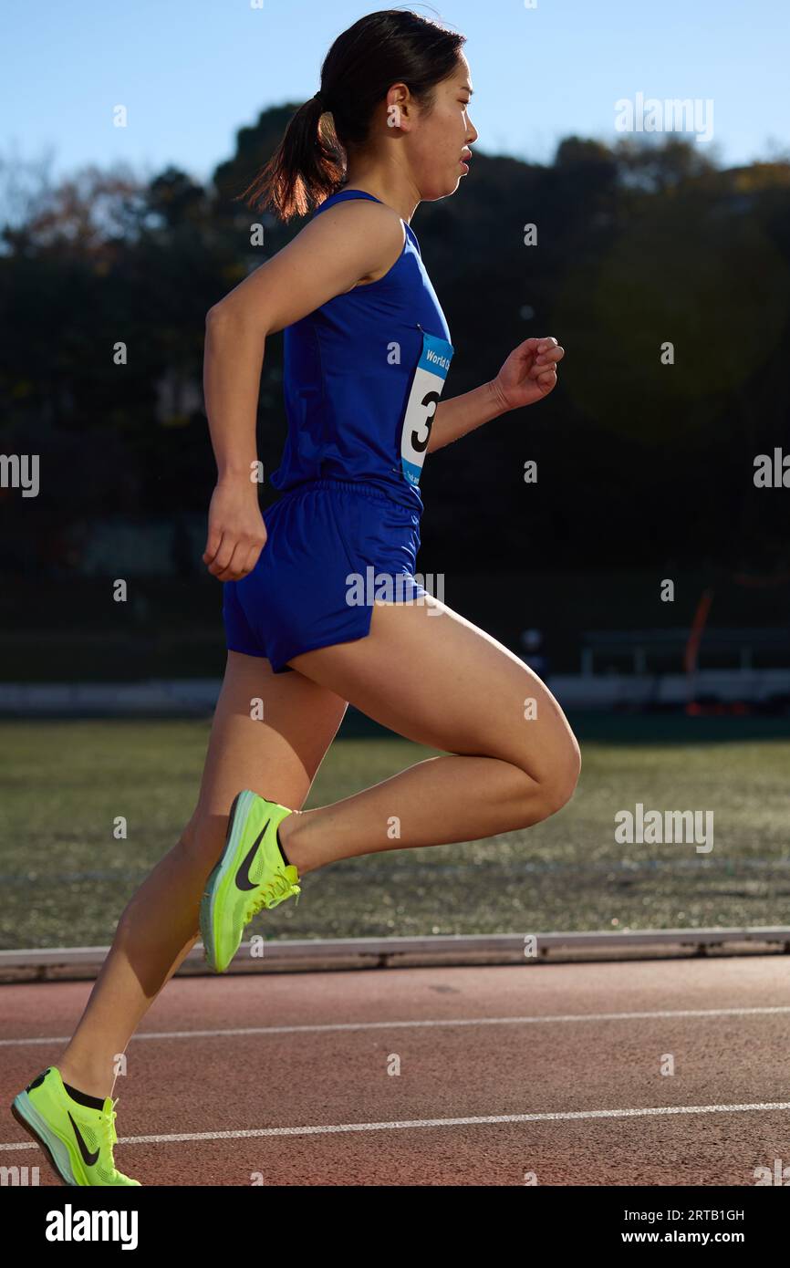 Japanese athlete running on track Stock Photo