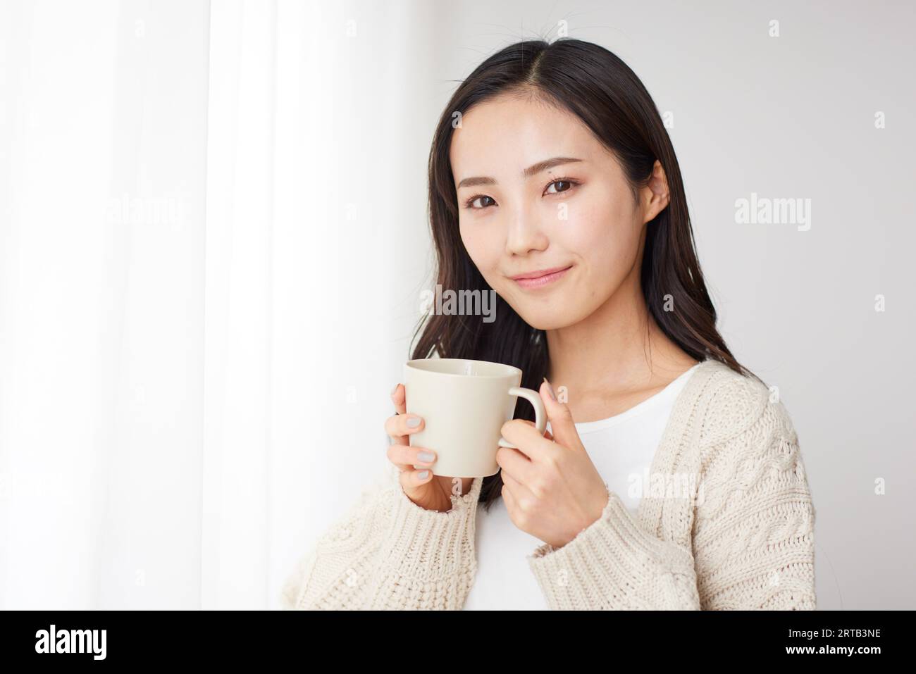 Young Japanese woman having a drink Stock Photo