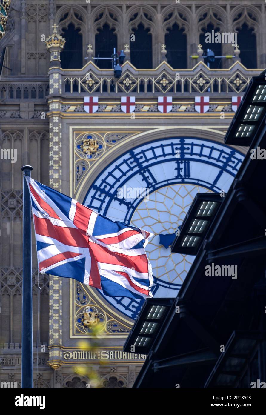 London, England, UK. Big Ben, the roof of Portcullis House and a Union Jack flag seen from the Victoria Embankment Stock Photo
