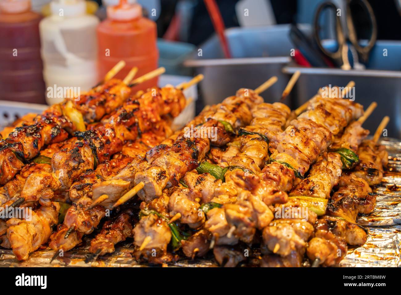 Grilling barbecue meat skewer kebab at traditional night market stall, delicious street food in South Korea. Stock Photo