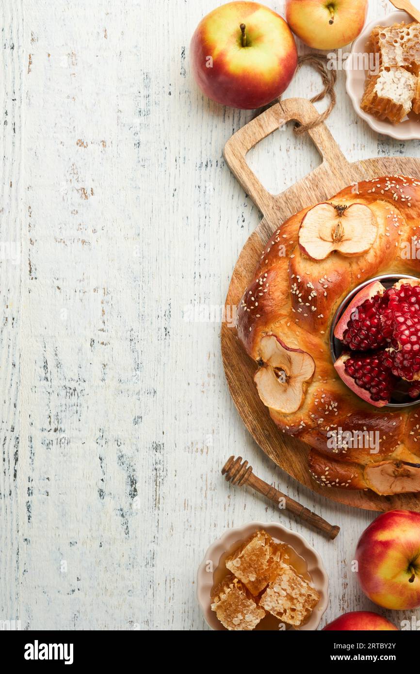 Jewish Holidays - Rosh Hashanah or Rosh Hashana. Pomegranate, apples, honey and round challah on old wooden white table background. Jewish Autumn cele Stock Photo
