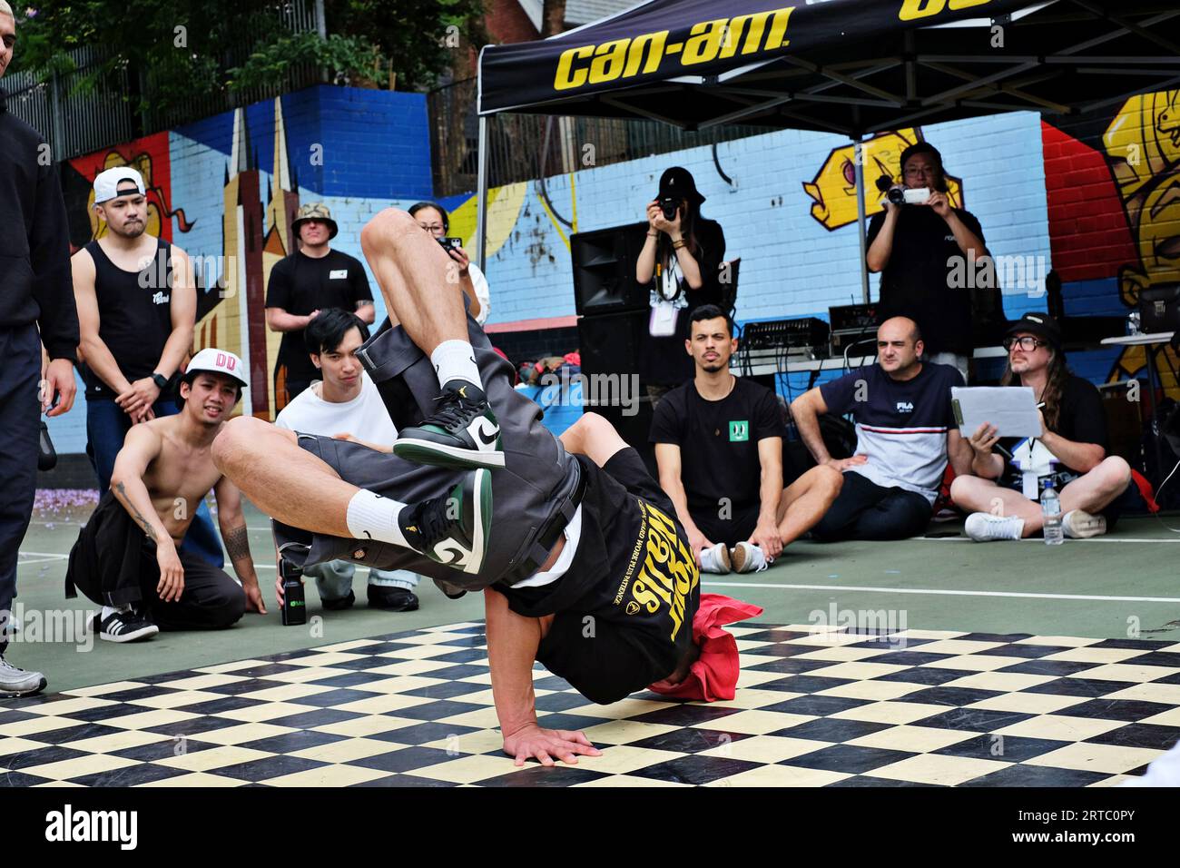 Head slide freeze, one arm down, Bboy with legs folded back breakdancing competition and battle performing Woolloomooloo, Sydney Stock Photo