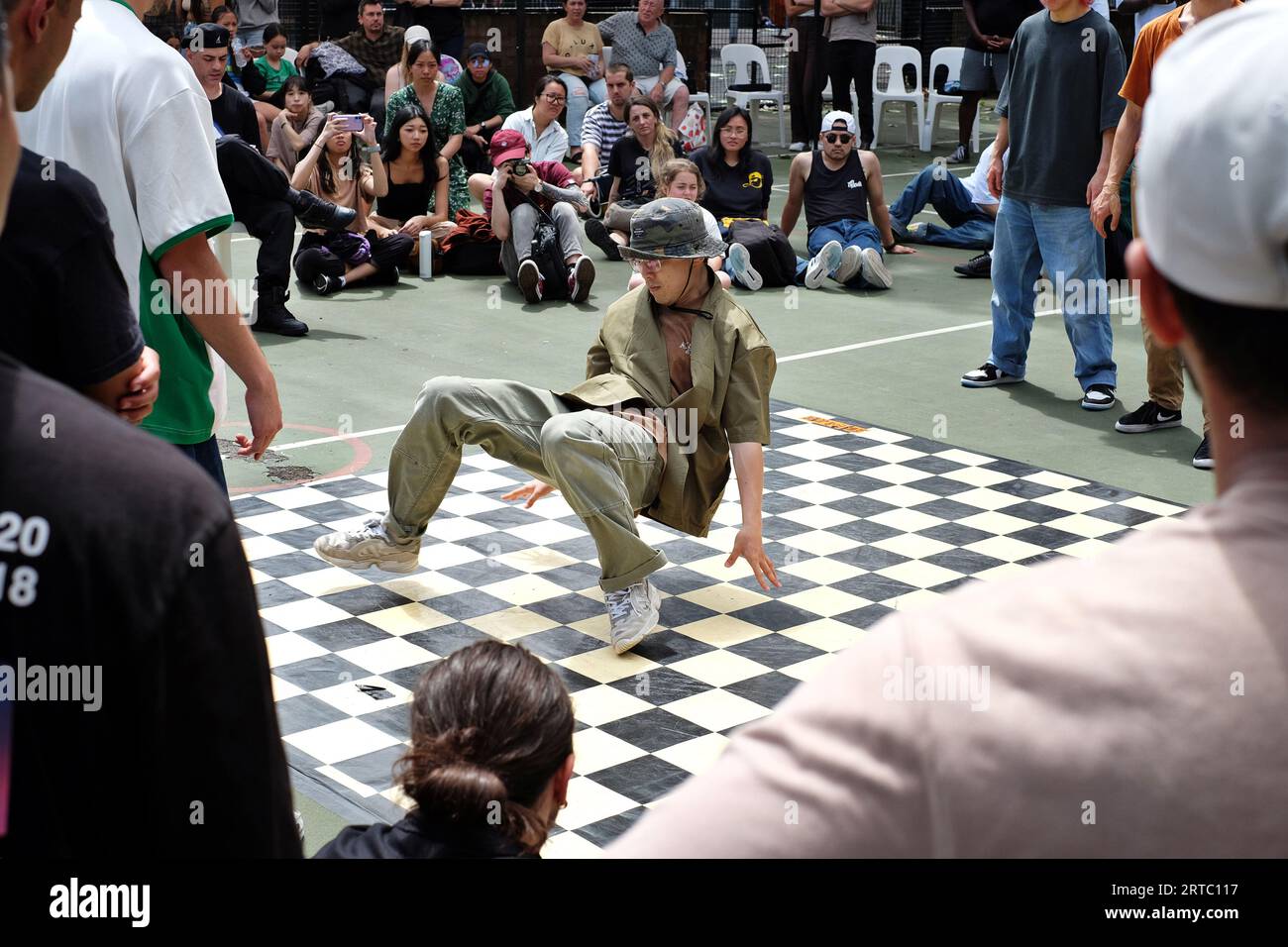 Breakdance 'Turtle' in a camo bucket hat - Breakdancing performances, competition and battles on the basketball courts of  Woolloomooloo, Sydney Stock Photo