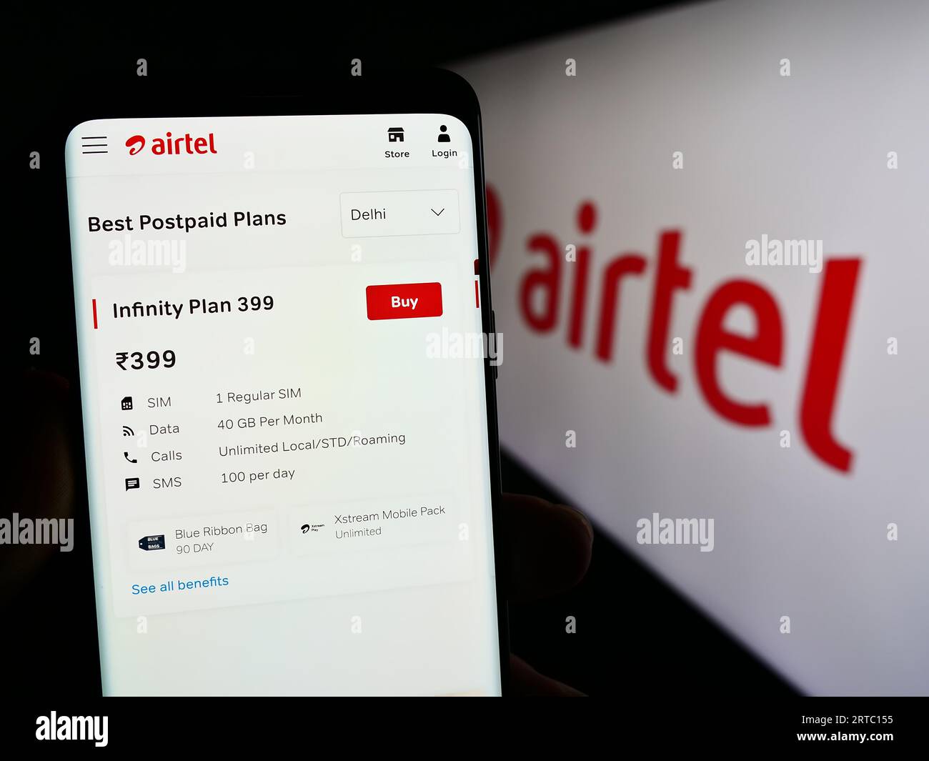 Person holding smartphone with web page of telecommunications company Bharti Airtel Limited on screen with logo. Focus on center of phone display. Stock Photo