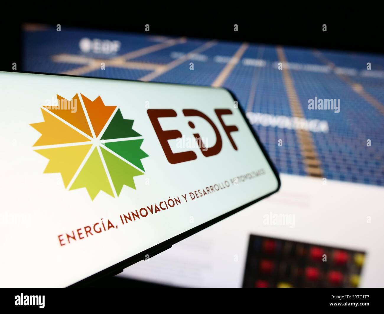Mobile phone with logo of Spanish photovoltaics company EiDF Solar on screen in front of business website. Focus on center-left of phone display. Stock Photo