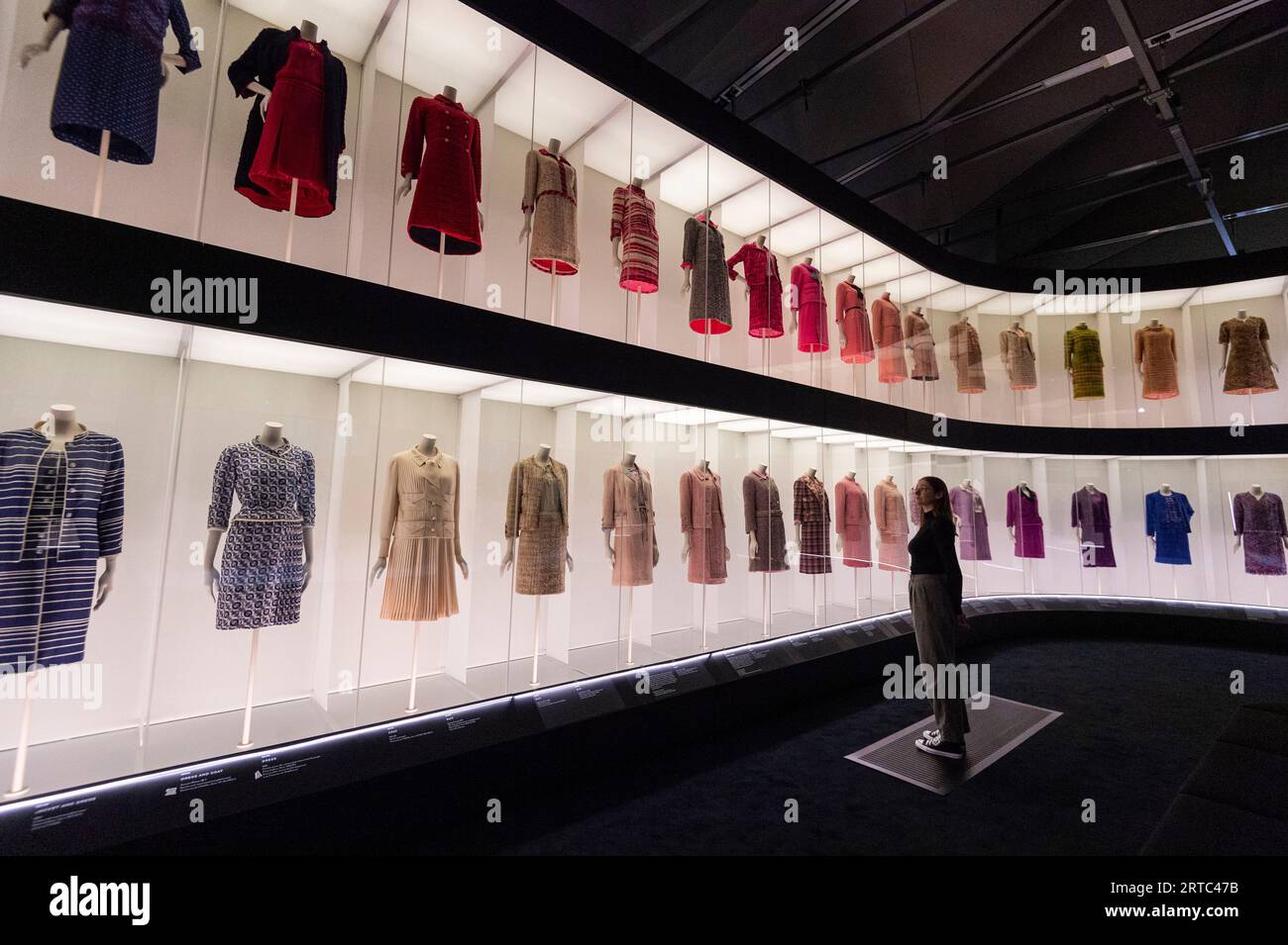 Embargoed to 00:01 Wednesday 13 September 2023] London, UK. 12 September  2023. A staff member views Chanel suit designs at a preview of 'Gabrielle  Chanel. Fashion Manifesto', the UK's first major exhibition