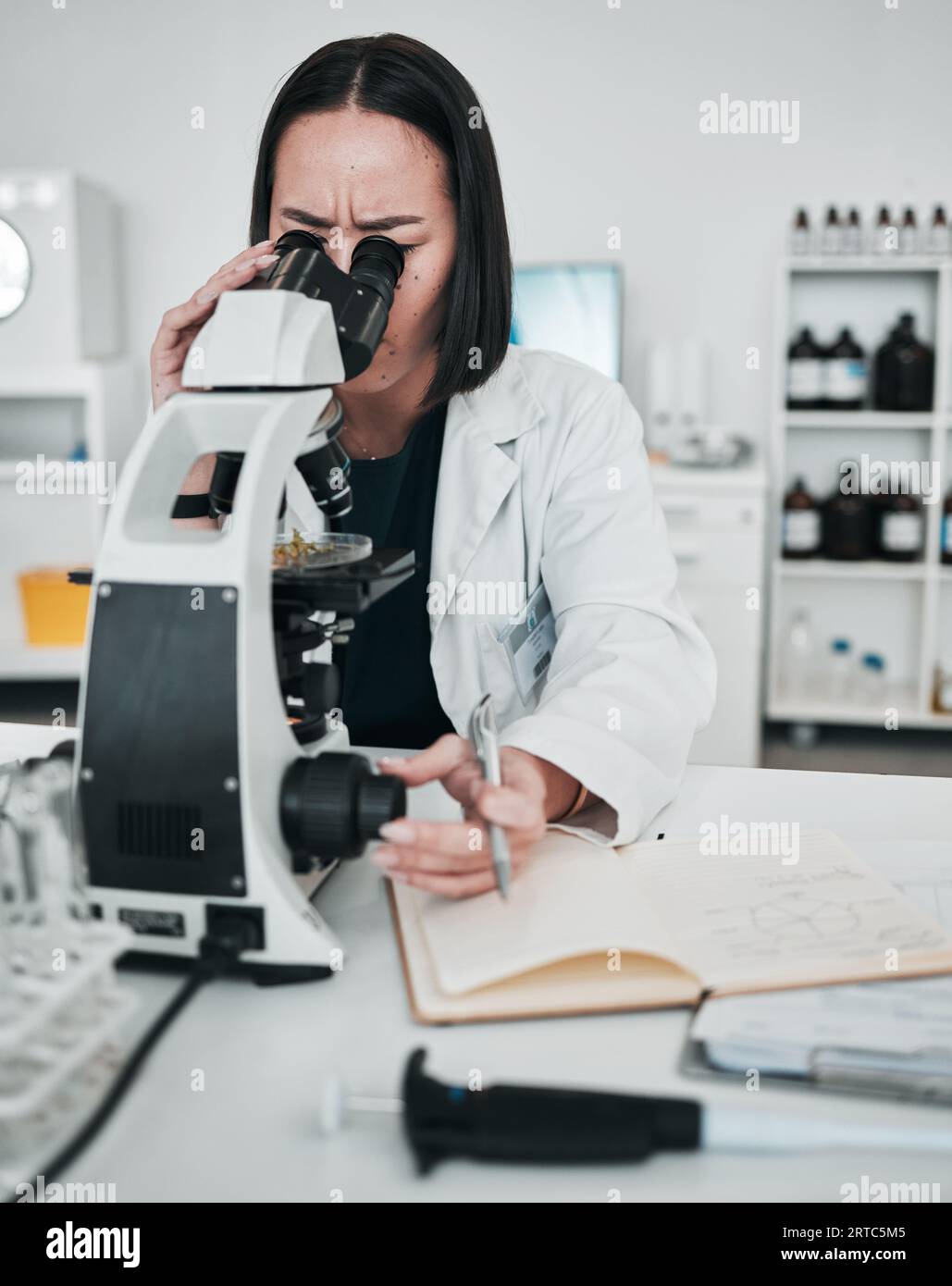 Microscope, woman and notes in laboratory for science research, dna ...