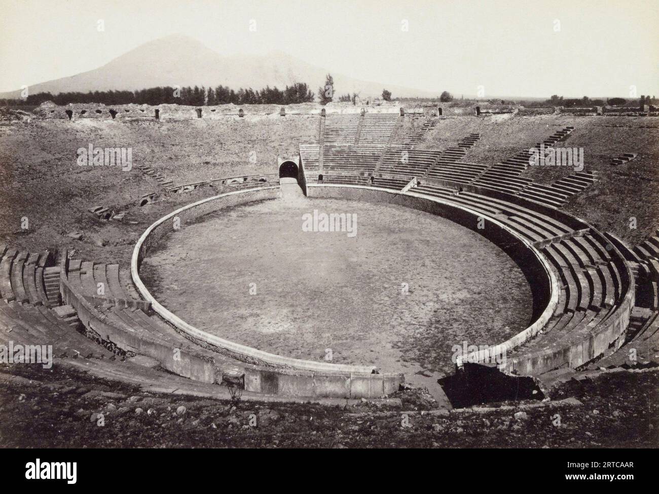 Pompeii Archaeological Site, Campania, Italy.   The excavated Amphitheatre as it was in the late 19th century.  Mt. Vesuvius, the volcano which destroyed the city can be seen in the background. Stock Photo