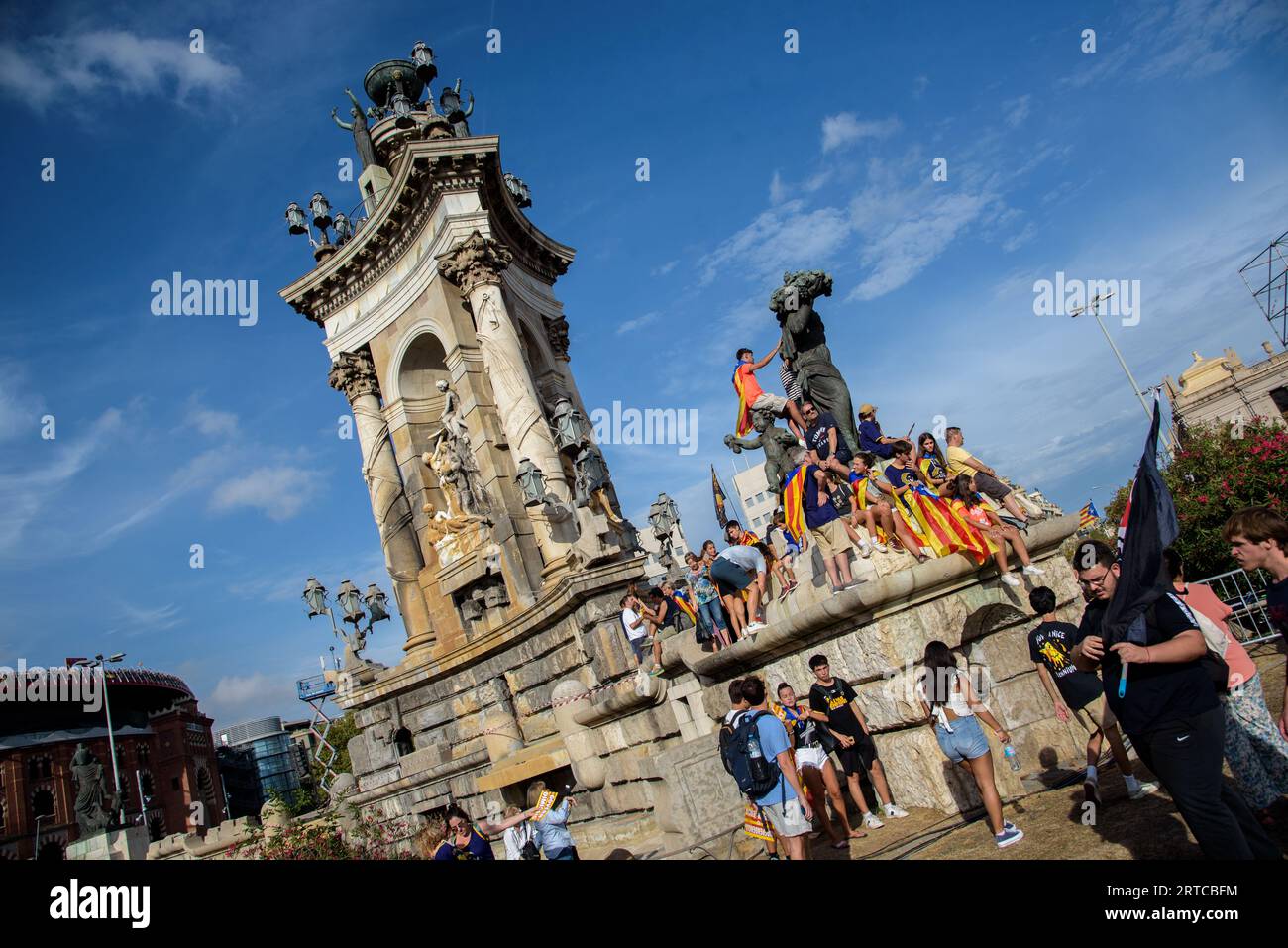 Barcelona, Catalonia, Spain - September 11, 2023: Participants in the National Day demonstration of Catalonia perched on the fountain of the Spain Squ Stock Photo