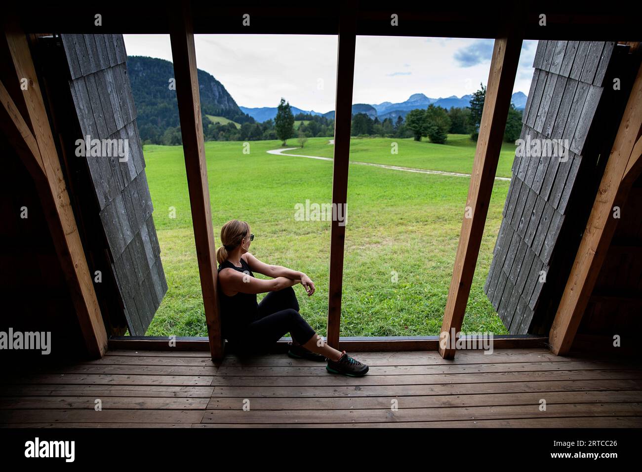 Mountain bike rider relaxing in a  beautiful wooden shelter on a cycling route near lake Bohinj in Triglav national park, Slovenia Stock Photo