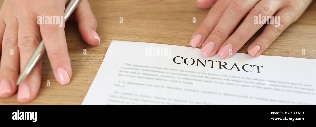 Female manager asks to sign contract while sitting at desk in office. Stock Photo