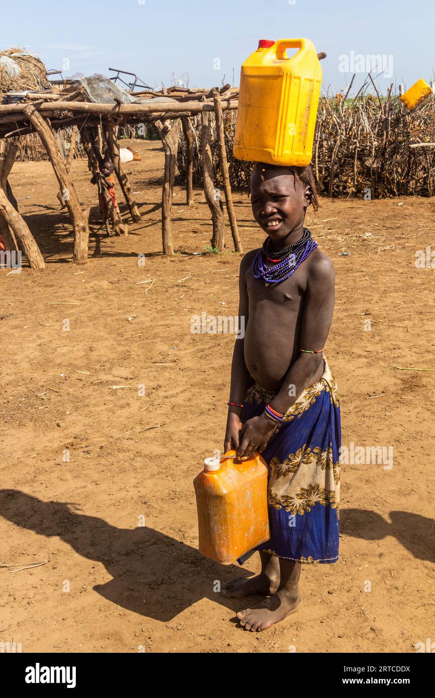 OMORATE, ETHIOPIA - FEBRUARY 5, 2020: Daasanach tribe girl collecting water near Omorate, Ethiopia Stock Photo