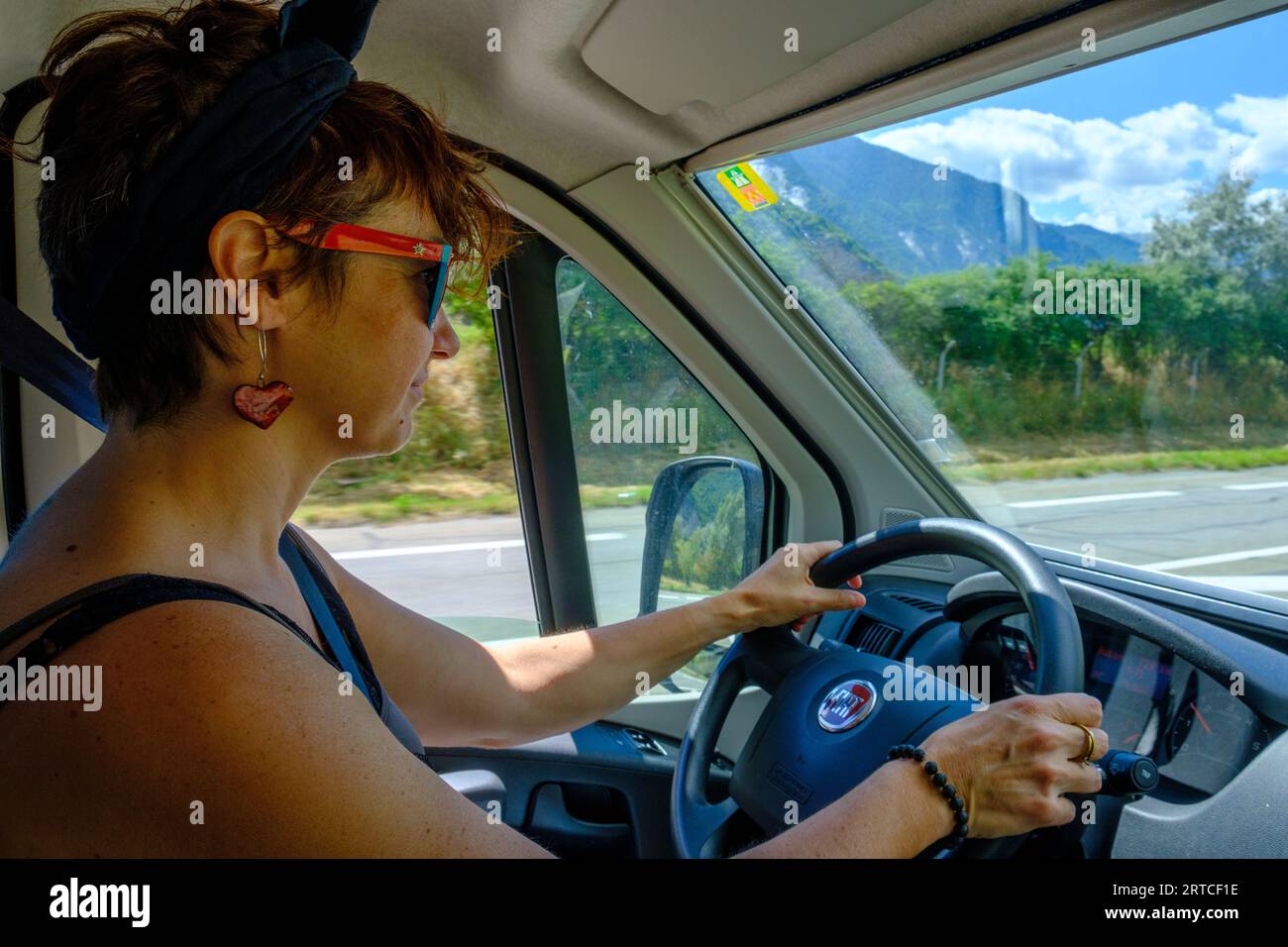 Shorthair brunette woman driving a camper van in France Stock Photo