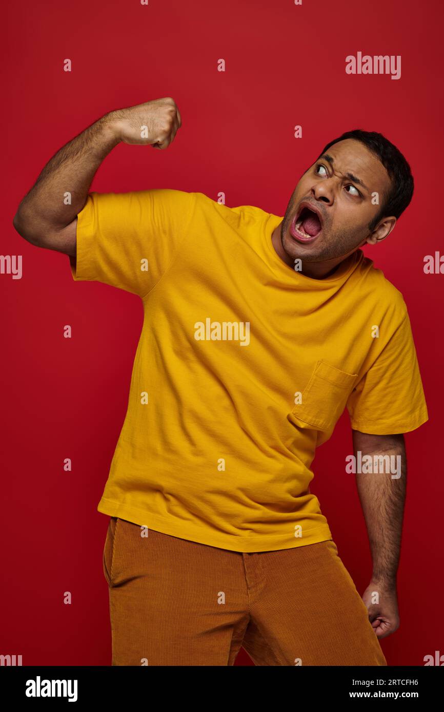 face expression, scared indian man in yellow tshirt punching himself