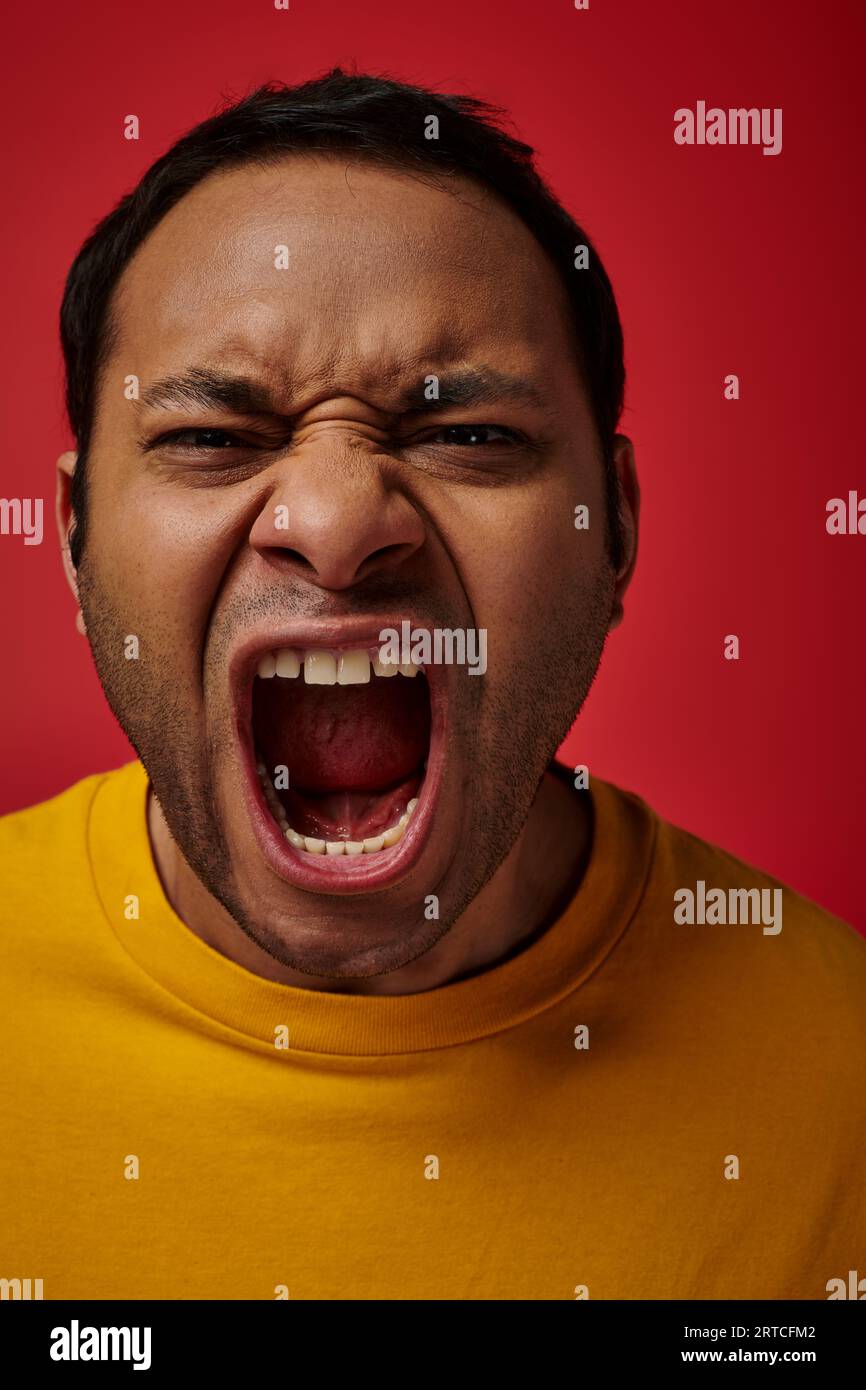 face expression, emotional indian man in yellow tshirt screaming on