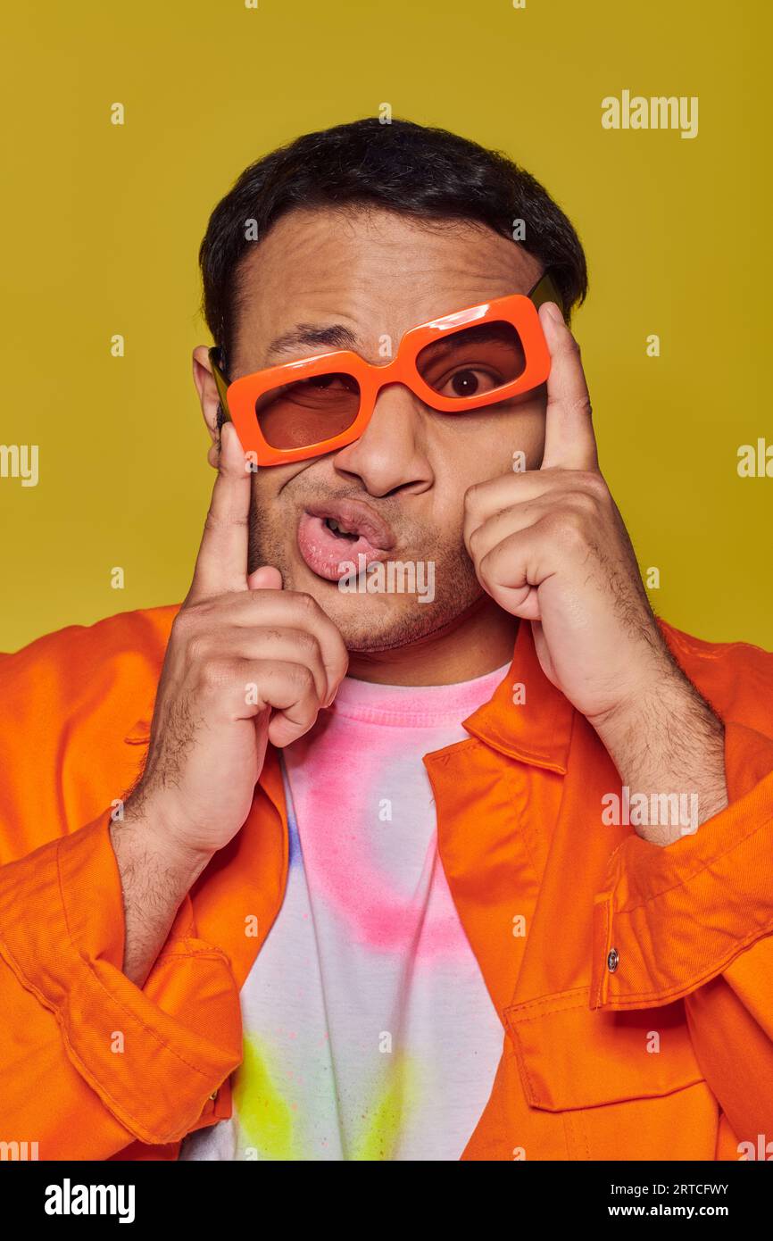 face expression, funny indian man adjusting orange sunglasses and