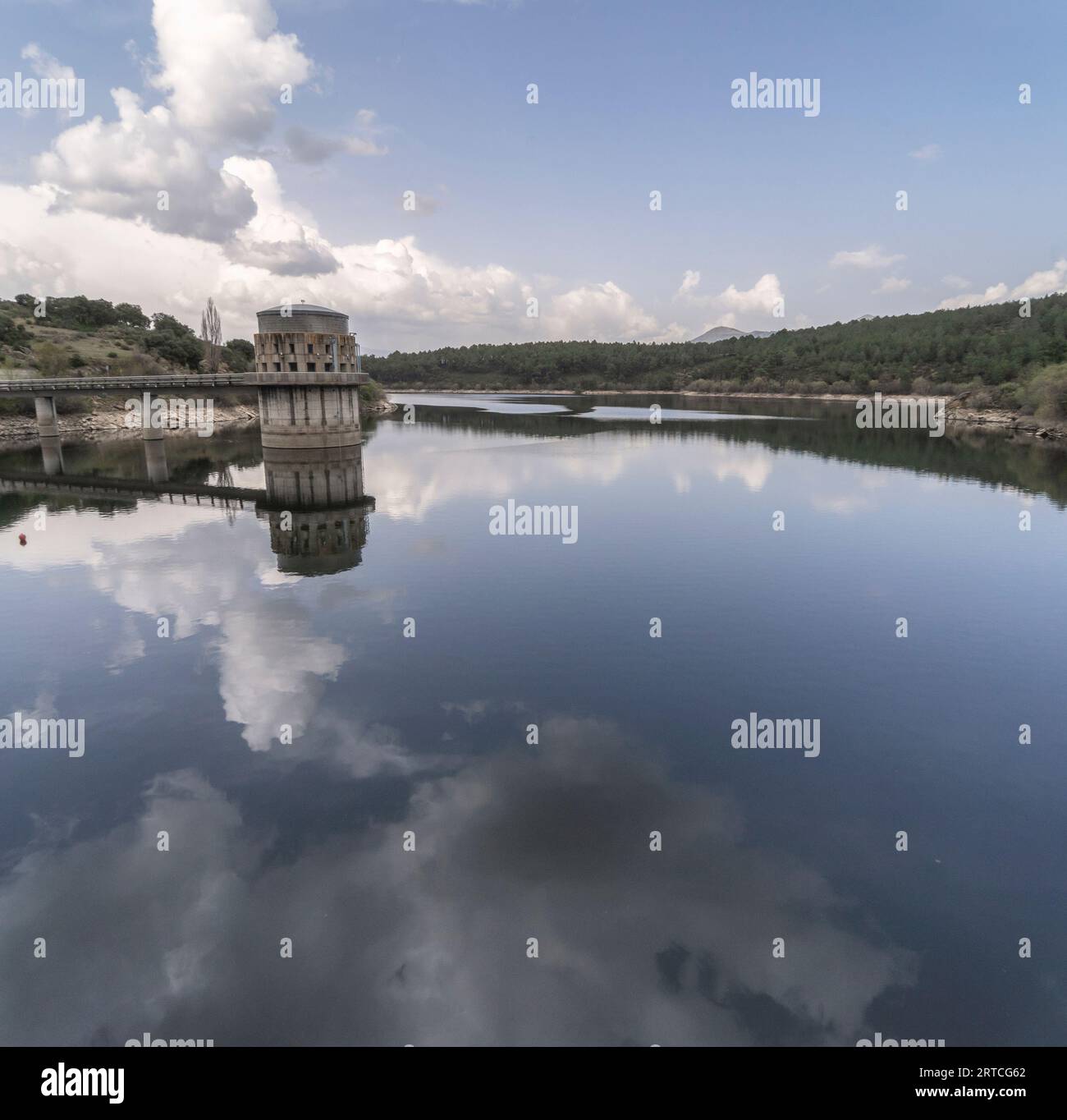 The El Villar reservoir in which we can see the water and how the architecture and clouds are reflected above it. Madrid. Stock Photo