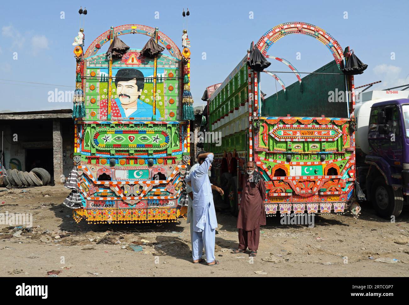 Traditional Pakistani jingle trucks outside a garage in the Khyber Pakhtunkhwa Province Stock Photo