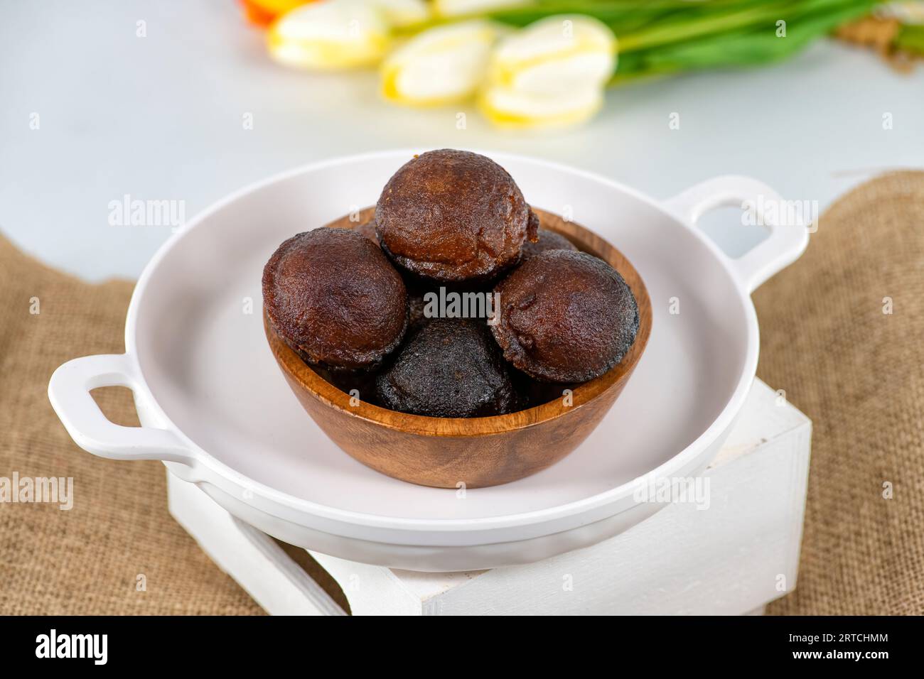 Unniyappam or Unni appam - Traditional kerala deep fried snack with rice dry coconut jaggery ghee, Unniyappam in a wooden bowl isolated Stock Photo