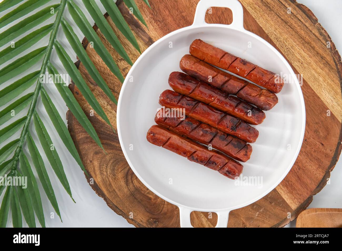 Top view of fried and Grilled sausages with sauce in a white plate and isolated back ground. Spicy chicken sausages fried in oil. Stock Photo