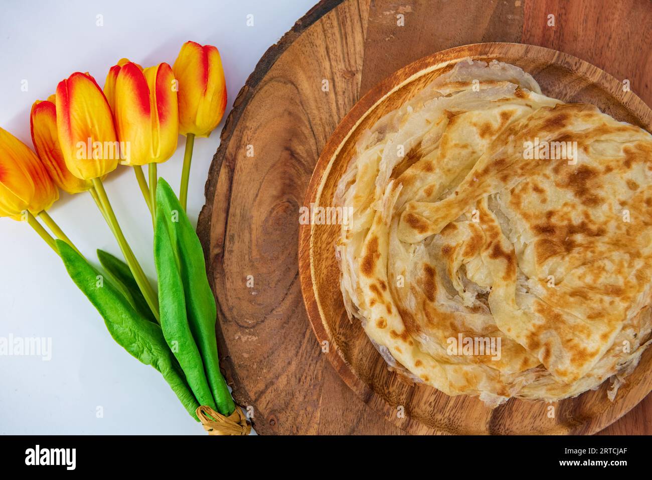Malabar parota in an isolated background. South Indian Porata in a wooden plate and decorated and isolated. Also called nool porata, Roti Parata Stock Photo