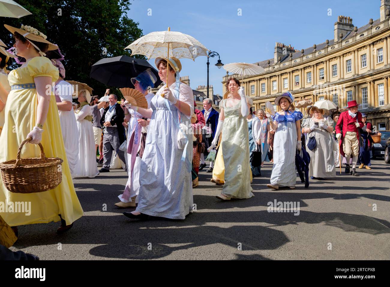 Jane Austen festival fans taking part in the world-famous Grand Regency Costumed Promenade are pictured as they walk around the Circus in Bath, UK Stock Photo