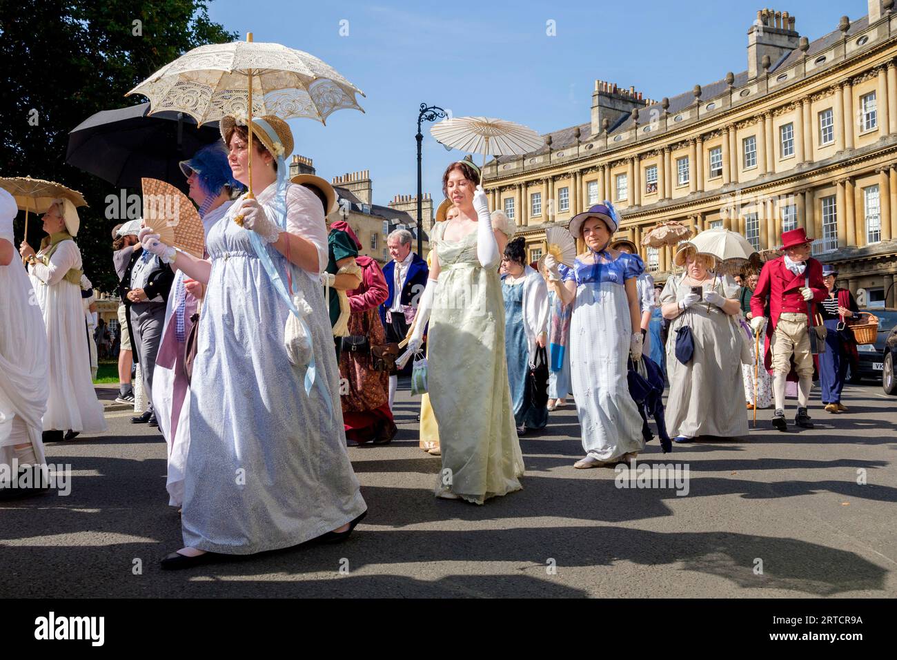 Jane Austen festival fans taking part in the world-famous Grand Regency Costumed Promenade are pictured as they walk around the Circus in Bath, UK Stock Photo