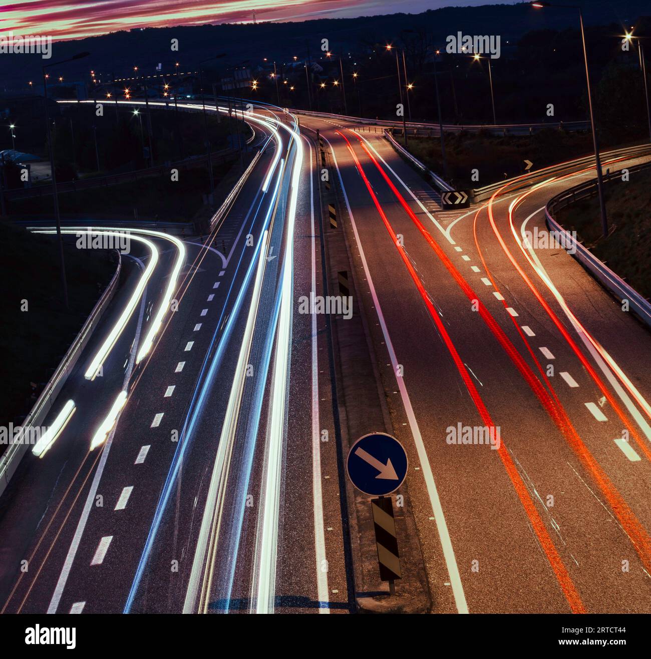 Trails of light from traffic on a highway in the early evening Stock Photo