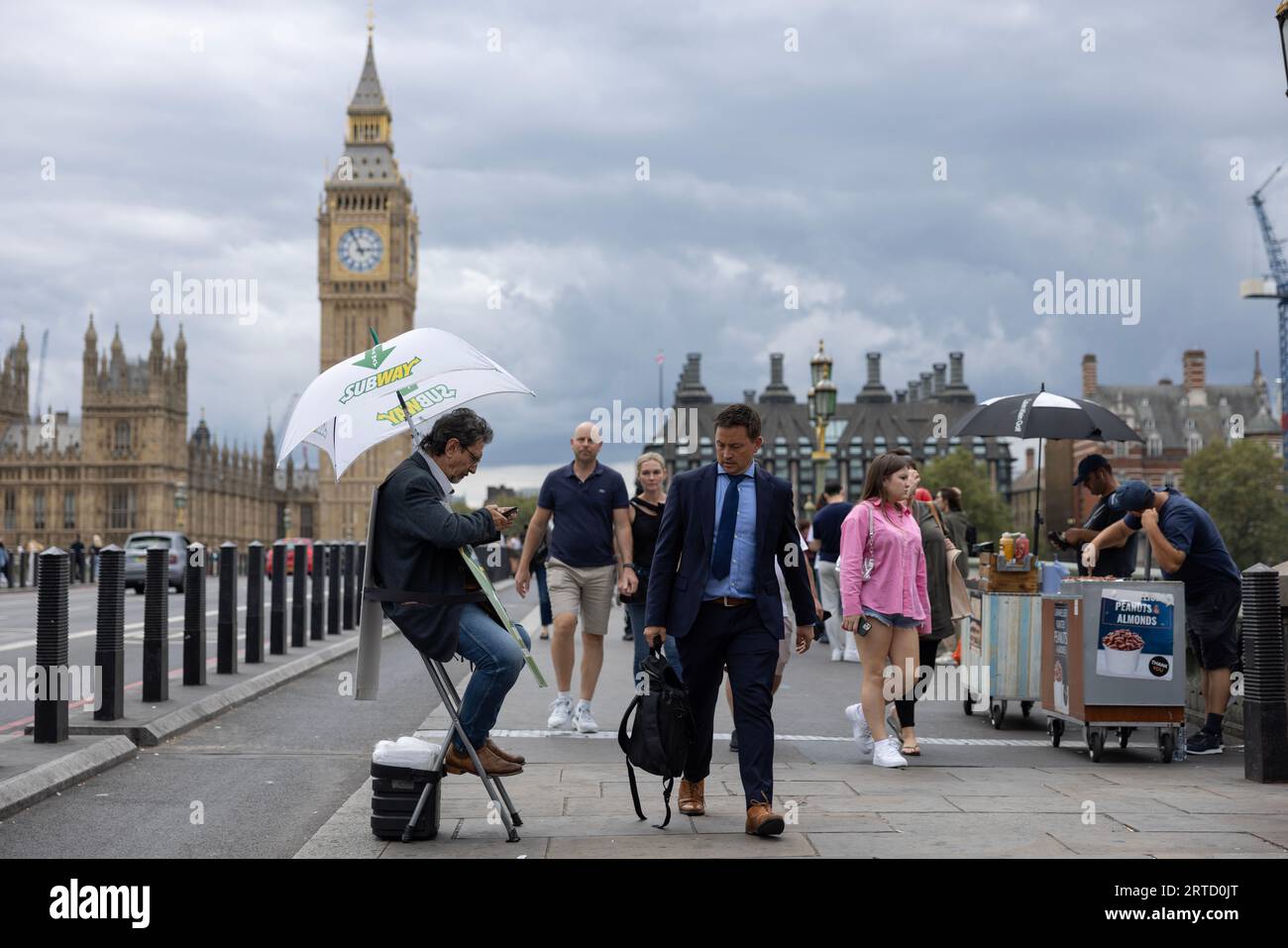 Man sitting on a folding chair promoting and giving directions to Subway fast food restaurant, Westminster Bridge, London, England, UK Stock Photo